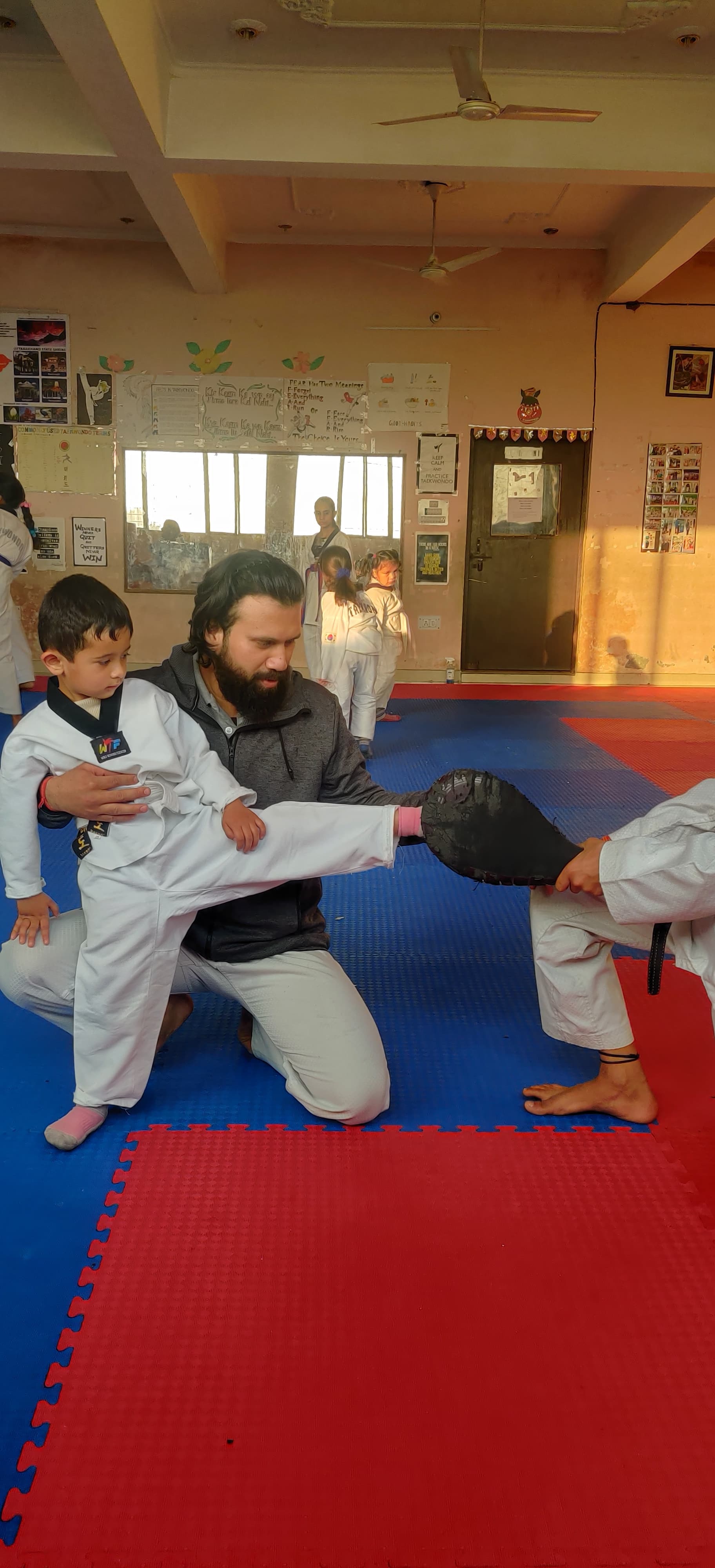 Master Abhishek demonstrating a kick to a student inside the dojang.